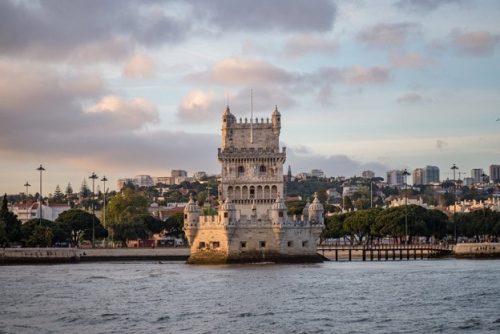 tower-belem-surrounded-by-sea-buildings-cloudy-sky-portugal_181624-10409